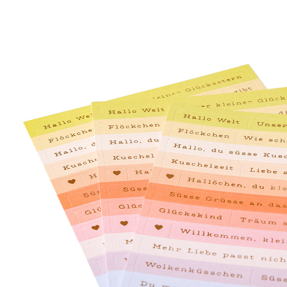 Farbenfrohe Alexandra Renke Deutsch-Satz-Aufkleberbögen, ideal zur Kartengestaltung oder zum Verzieren, werden auf einem weißen Hintergrund aufgefächert.