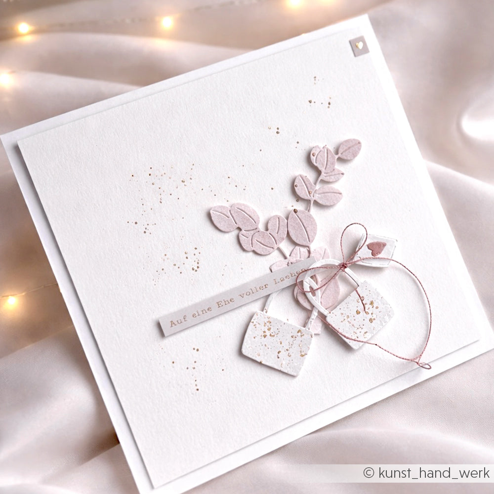 Elegante handgefertigte Alexandra Renke Karte mit zarten rosa Blättern, Anhängern und deutschem Text auf weiß mit Goldspritzern - perfekt für die Kartengestaltung oder zum Verzieren mit Hochzeitsbotschaften Aufklebern.