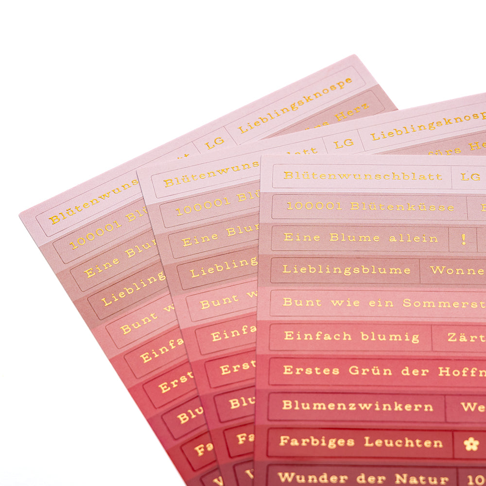 Drei Bögen Alexandra Renke rosa Farbverlauf Sticker-Streifen mit deutschen goldgeprägten Sprüchen, ideal für die Kartengestaltung, werden auf einer weißen Fläche aufgefächert.