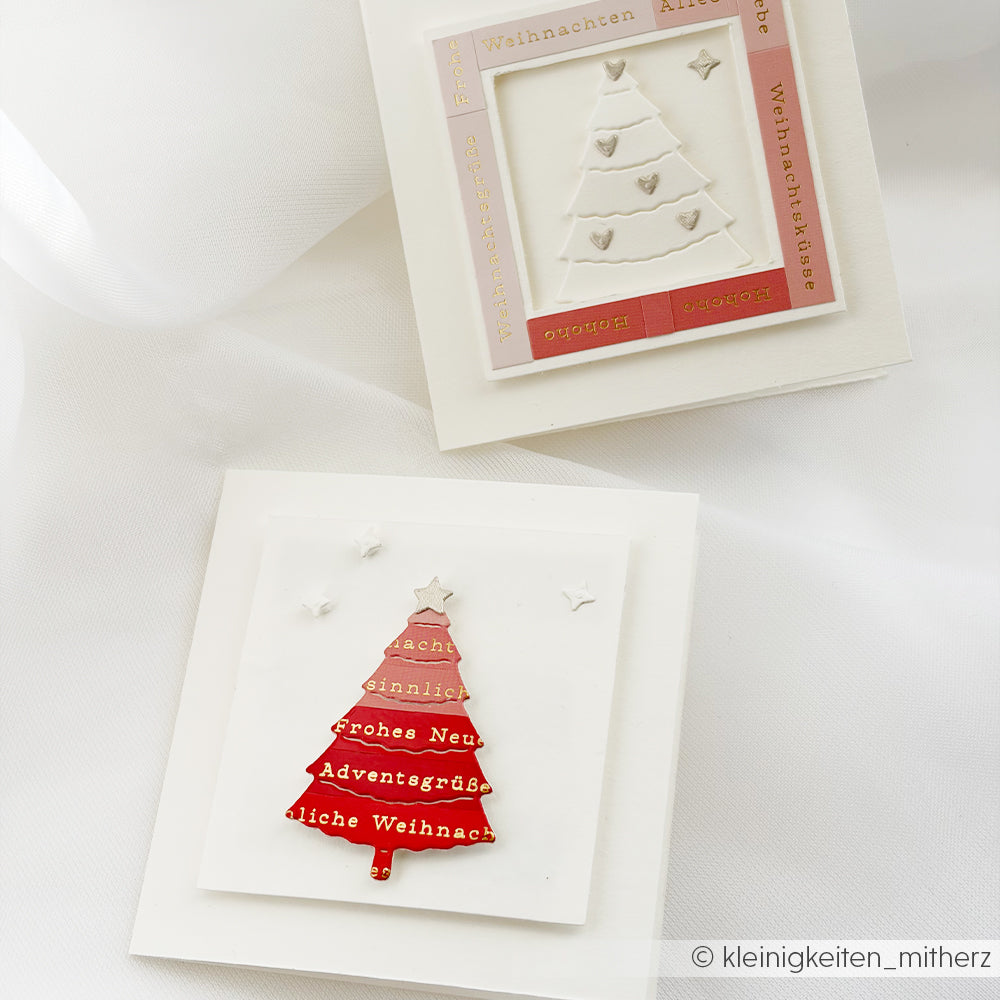 Zwei handgefertigte Weihnachtsgrüsse-Karten mit geprägten Weihnachtsbaum-Motiven und einem roten Farbverlauf.