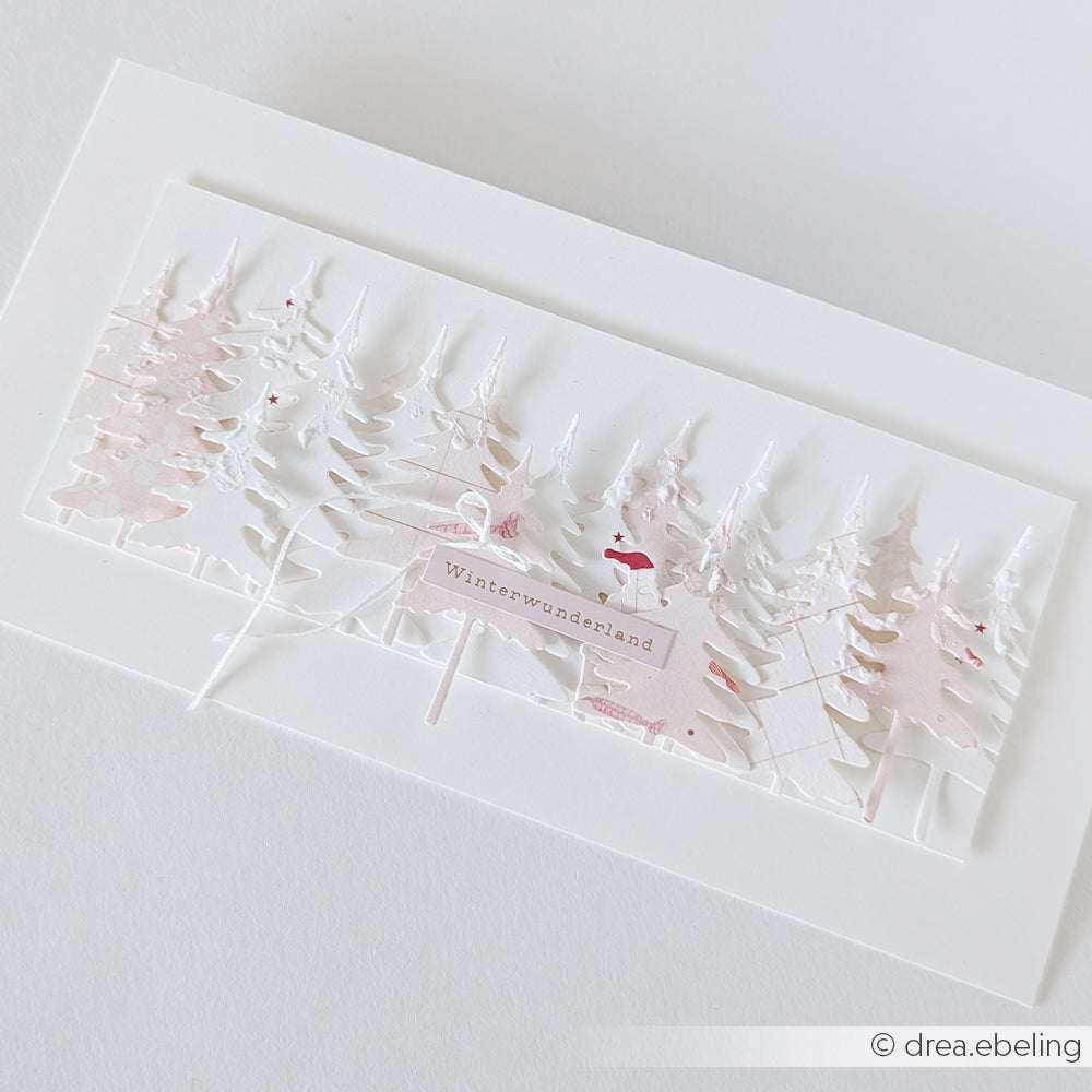 Mehrschichtige Papierbastelei eines Waldes mit einem Winterwunderland-Schild für die Gestaltung von Winterspass-Karten.