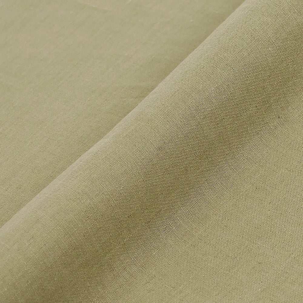 Nahaufnahme des hellolivgrünen DMC Hanf Stoffes mit feiner Struktur und weicher Diagonalfalte.