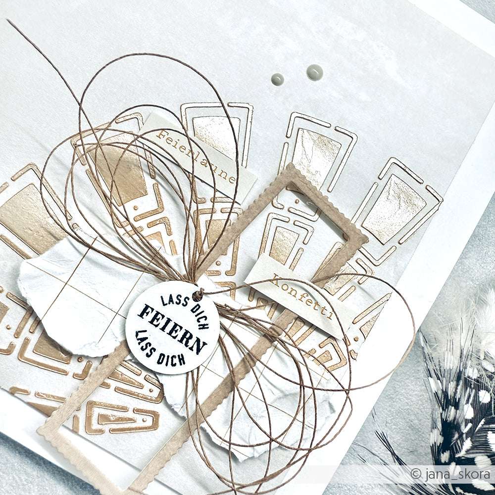Handgemachte Karte von Alexandra Renke mit geschichtetem Papier, Schnurschleife, deutschem Text und beige-weißen geometrischen Mustern - ideal für Papierprojekte oder als einzigartige Stencil Farbkarte.
