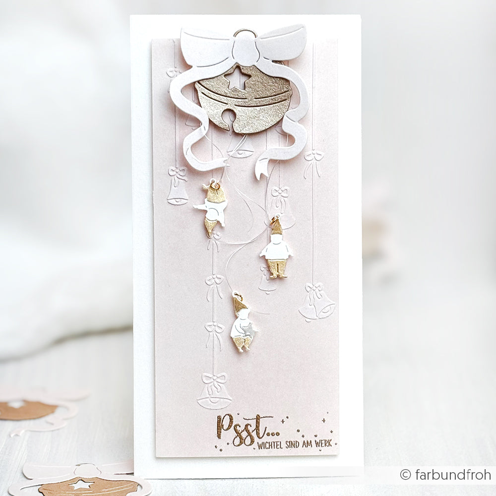 Handgefertigte Karte von Alexandra Renke mit goldenen und weißen Engeln, die an einem Band hängen, hergestellt mit wiederverwendbaren Schablonen und mit dem Text "Psst... Wichtel sind am Werk" am unteren Rand.