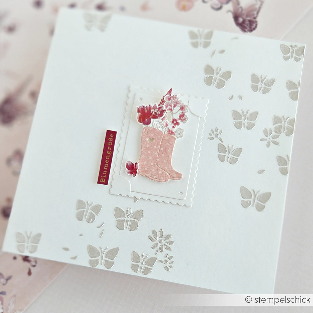 Quadratische Karte von Alexandra Renke mit rosa Stiefeln und Blumen, umrahmt von geprägten silbernen Schmetterlingen, gestaltet mit der Schablone „Florale Schmetterlinge“ – ideal für Schablonen-Papierprojekte und um ihnen eine zarte Note zu verleihen.