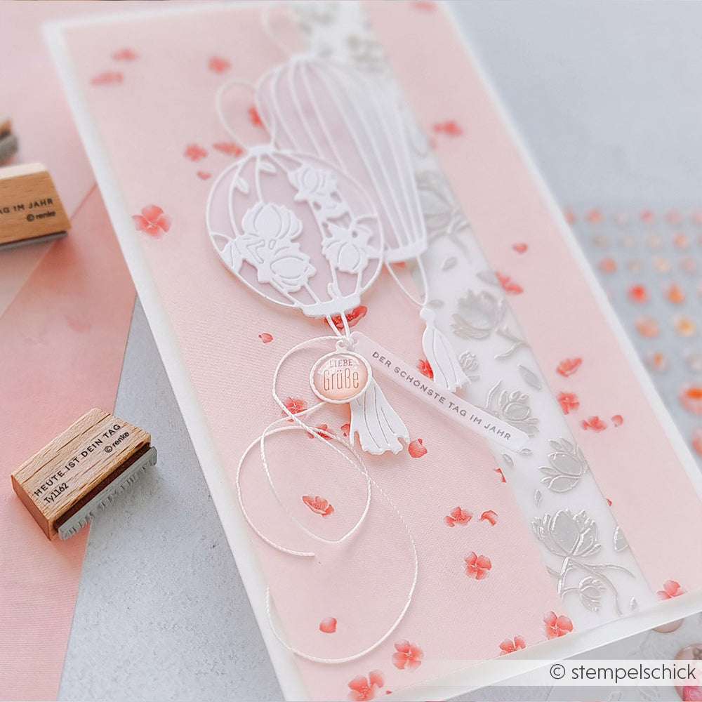 Handgefertigte rosa-weiße Karte von Alexandra Renke mit floralen Motiven, geprägten Herzen, Schablonen und kleinen Korallenblütenverzierungen.