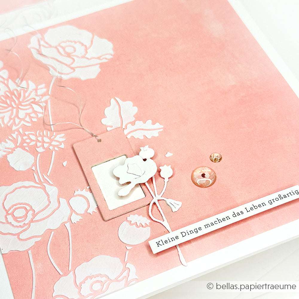 Rosafarbene Blumenkarte von Alexandra Renke mit weiß geprägten Blumen, einem Hasenausschnitt und deutschem Text - ideal für Schablonen Papierprojekte mit einer wiederverwendbaren Schablone Mohnwirbel für einzigartige, kreative Designs.