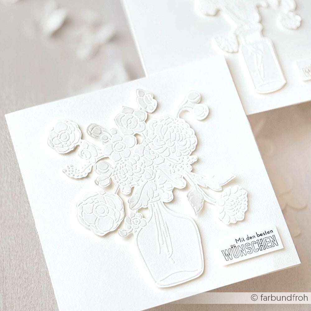 Weiße, geprägte Grußkarte von Alexandra Renke mit einer Blumenvase, einer wiederverwendbaren Blumenstrauß-Schablone und dem deutschen Text "Mit den besten Wünschen" auf der Vorderseite.