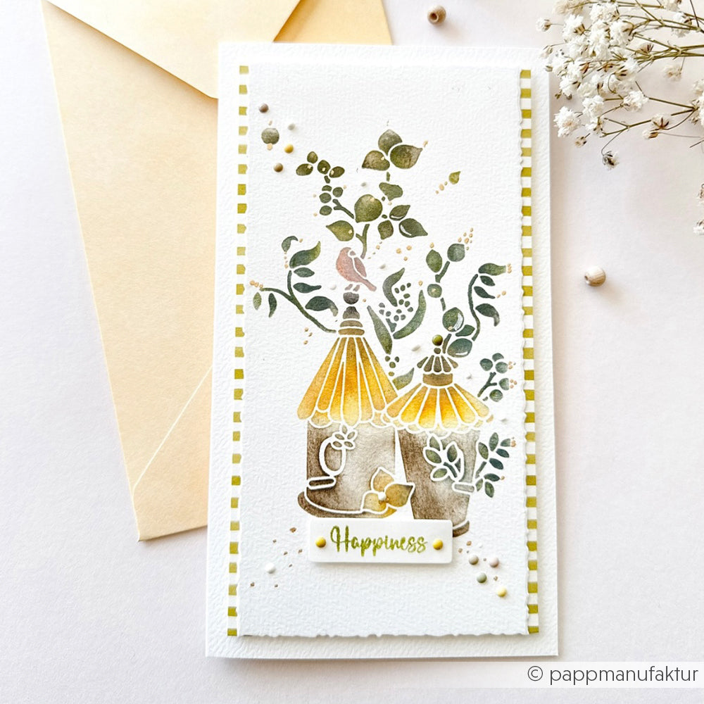 Handgefertigte Karte mit Vogelkäfigen, Vögeln und Blättern, verziert mit dem Schriftzug „Happiness“ auf weißem Hintergrund. Gestaltet mit einer wiederverwendbaren Schablone von Alexandra Renke für zusätzliche Details und einen besonderen Charme.