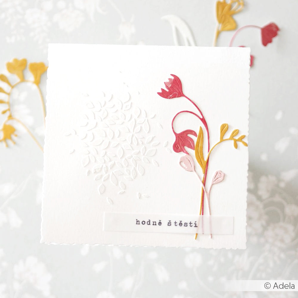 Handgefertigte Karte von Alexandra Renke mit geprägten Blättern, hergestellt mit wiederverwendbaren Schablonen, verziert mit roten und gelben Papierblumen, mit der Aufschrift "hodně štěstí" (viel Glück).