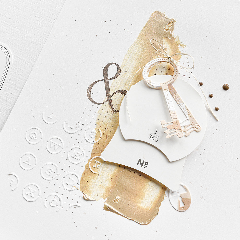 Abstrakte Kunst mit beigen und braunen Pinselstrichen, einem Papierausschnitt und geprägten Symbolen auf weißem Papier, mit Alexandra Renke Schablonen inspiriert von Schreibmaschine-Tastatur Stencil für ein einzigartiges, wiederverwendbares Design.