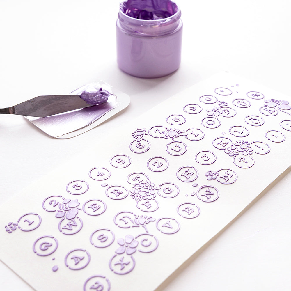 Alexandra Renke lila Buchstaben- und Zahlenschablonen, Strukturpaste, Spachtel, wiederverwendbare Florale Schreibmaschine Schablonen und lavendelfarbene Farbe - ideal für kreative Schablonenpapierprojekte auf weißem Untergrund.