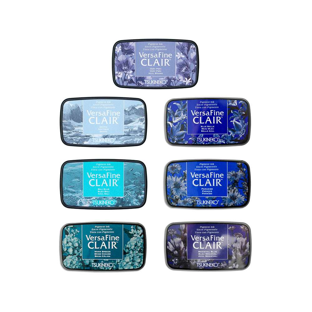Sieben Tsukineko VersaFine Clair Stempelkissen in verschiedenen Blau- und Teal-Tönen, die mit satten Pigment-Tinten versehen sind, sind in einem vertikalen Stapel angeordnet.