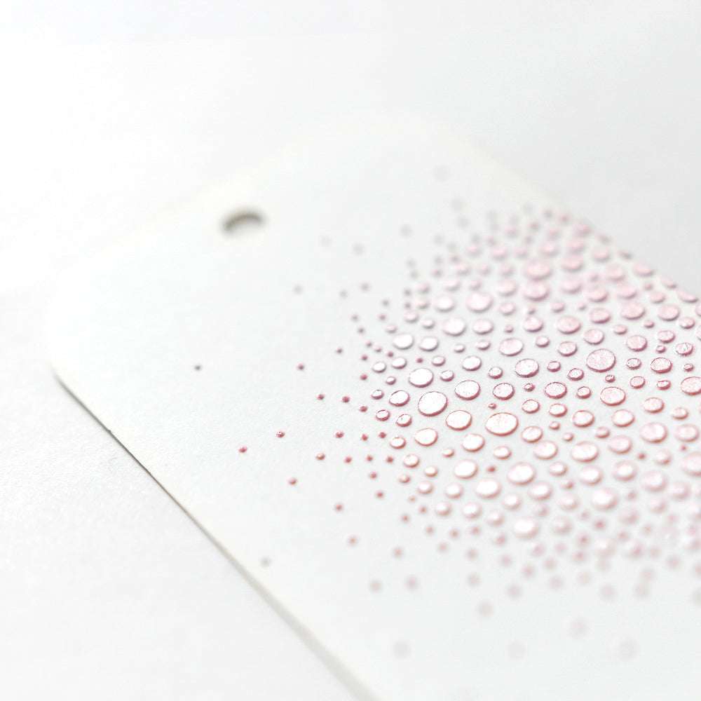 Der weiße Anhänger von Crafters Workshop hat ein Loch und erhabene rosa Punkte, die nach außen hin verblassen - ideal, um mit Stencil Butter oder anderen Mischtechniken Texturen hinzuzufügen.