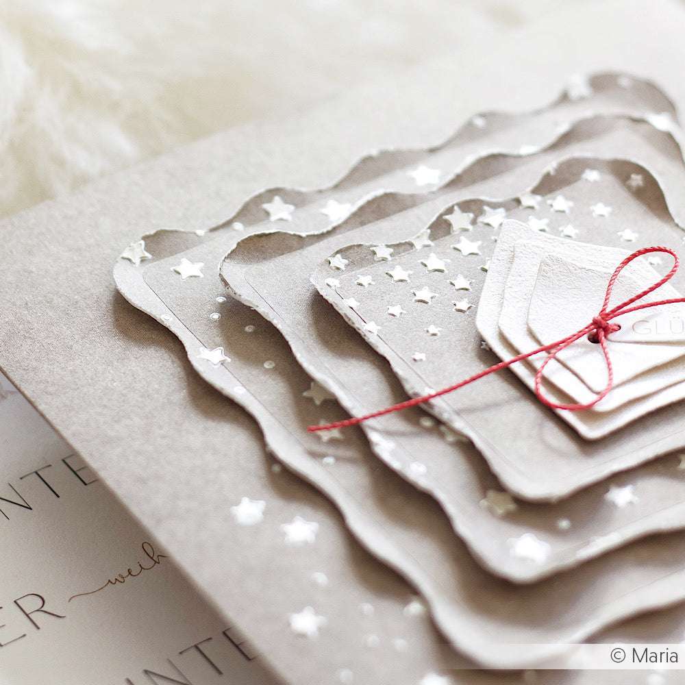 Das mehrlagige Sternenpapier mit Wellenkanten von The Crafters Workshop, das mit roter Schnur auf neutralem Hintergrund gebunden ist, eignet sich perfekt für Mixed-Media-Kreationen.