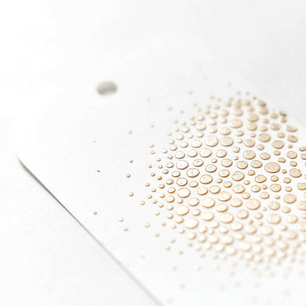 Der weiße Anhänger von Crafters Workshop mit abgerundeten Ecken hat erhabene goldene Punkte, die mit Stencil Butter hergestellt wurden, und ein kleines Loch an der Oberseite - ideal, um Mixed-Media-Projekten Struktur zu verleihen.