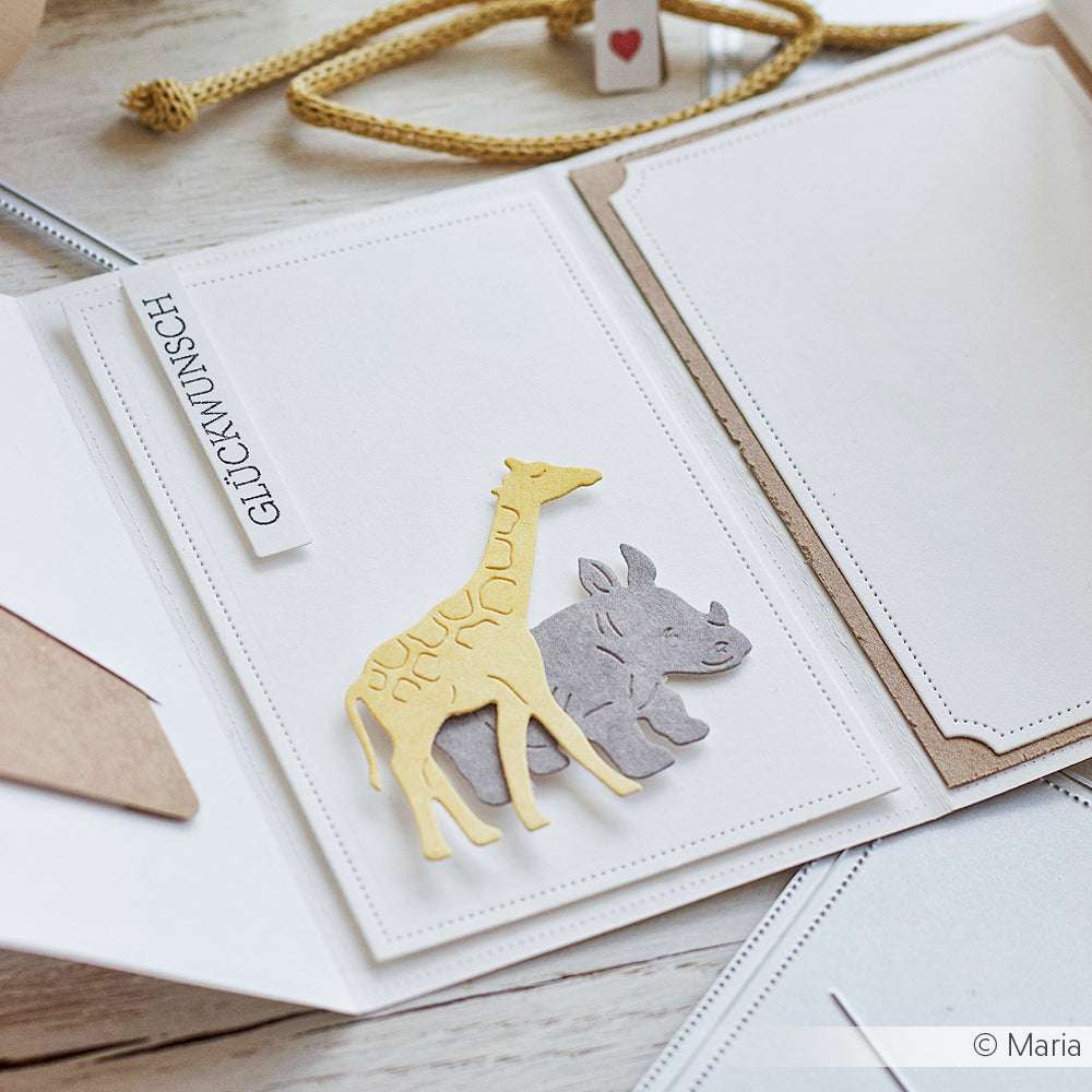 Handgemachte Karte mit ausgestanzter Giraffe und Nashorn unter Verwendung der Alexandra Renke Motivstanze Tierparade Dies und einem weißen Anhänger mit der Aufschrift GLÜCKWUNSCH.