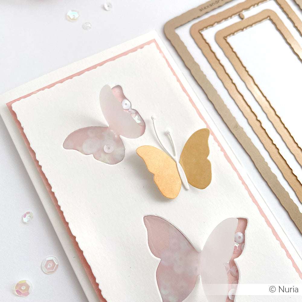 Handgemachte Karte mit Schmetterlingsausschnitten aus der Motivstanze Schichtschmetterling 6 von Alexandra Renke, verziert mit Pailletten und goldenen Formen auf weißem und rosa Designpapier. Perfekt für jeden Anlass!.