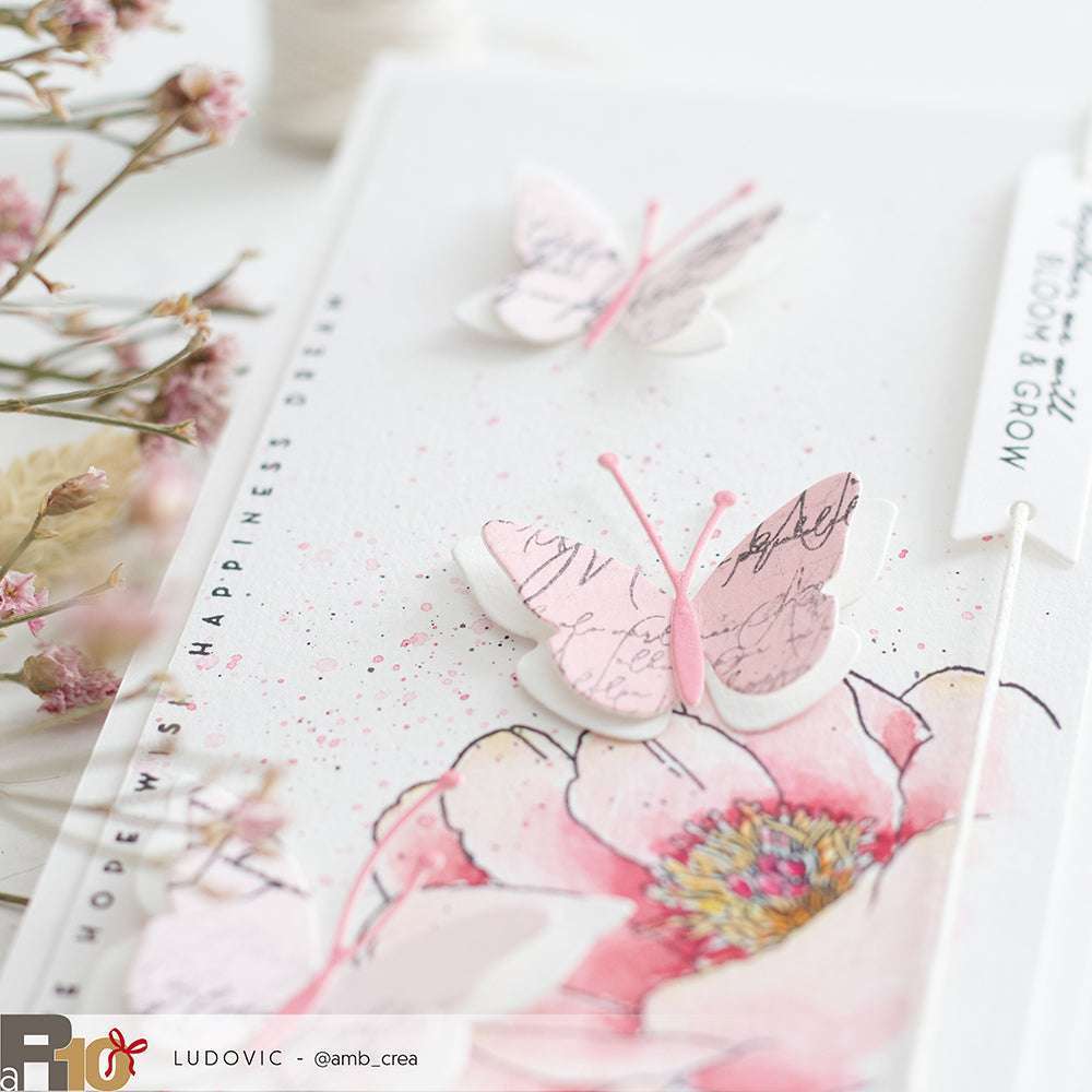 Handgefertigte Karte mit rosafarbenen Schmetterlingen und einer großen Blume, hergestellt mit Alexandra Renke Motivstanze Schichtschmetterling, mit zarten Details und weichen Aquarelleffekten.
