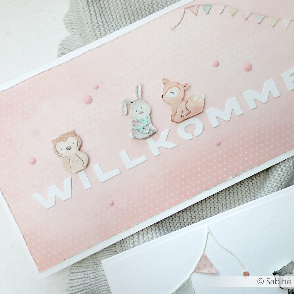Rosafarbene Karte mit dem Text "WILLKOMMEN" und niedlichen Eulen-, Hasen- und Reh-Illustrationen, hergestellt mit dem Alexandra Renke Motivstanze Mini Tier Set und pastellfarbenen Designpapieren - perfekt für charmante Dekorationen.