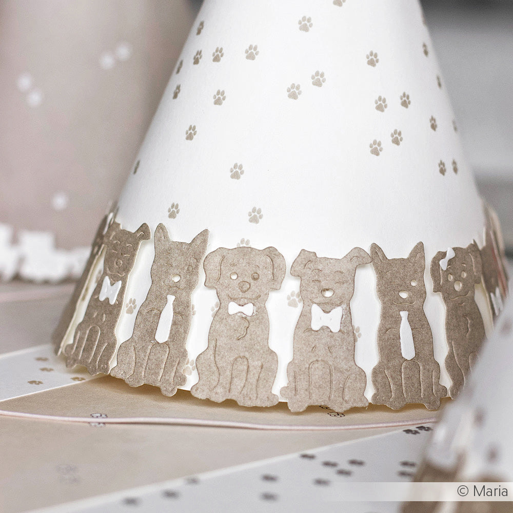 Weißer Partyhut mit einer Umrandung aus braunen Hundeausschnitten und winzigen Pfotenabdrücken, hergestellt mit Alexandra Renke Motivstanze Schmucke Hunde Dies für charmante, individuelle Details.
