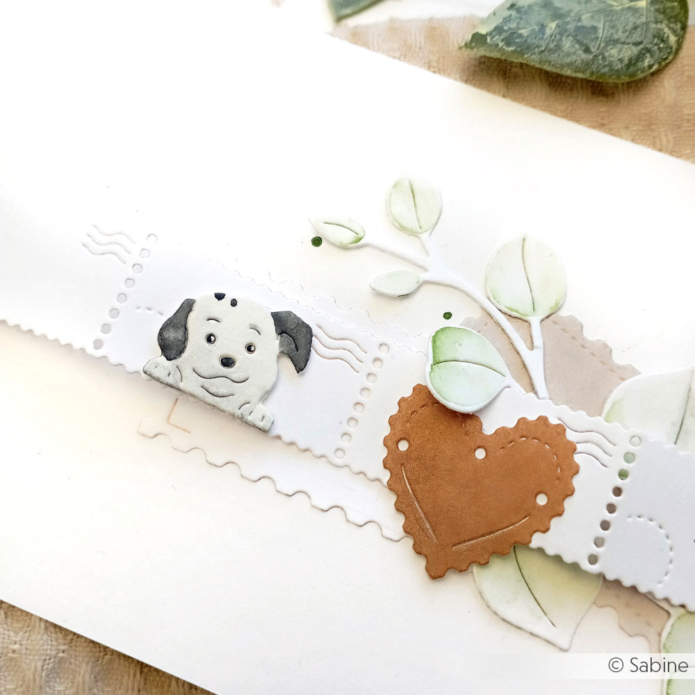 Handgefertigte Karte mit einer Welpenillustration, Papierblättern und einem braunen Herz auf weißem Hintergrund, erstellt mit Alexandra Renke Motivstanze Schmucke Hunde Dies.