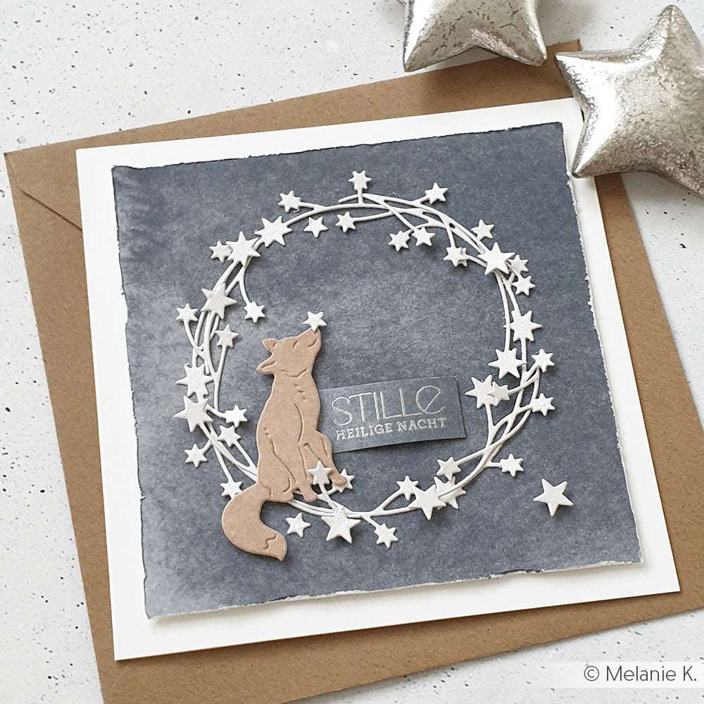 Handgefertigte Alexandra Renke Karte mit einem Fuchs aus dem Motivstanze Fuchs Trio, Sternkranzrahmen und "STILLE HEILIGE NACHT" Text auf grauem Hintergrund.