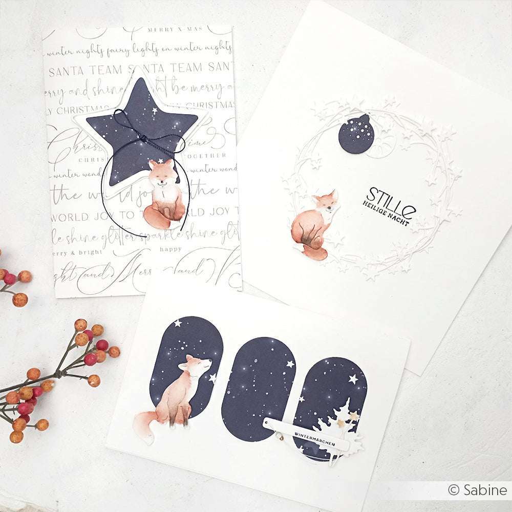 Drei illustrierte Weihnachtskarten mit Füchsen, Sternen und winterlichen Motiven auf Weiß mit Beeren - wunderschön gestaltet mit der Alexandra Renke Motivstanze Fuchs Trio Stanzen für Papier für charmante Ergebnisse.