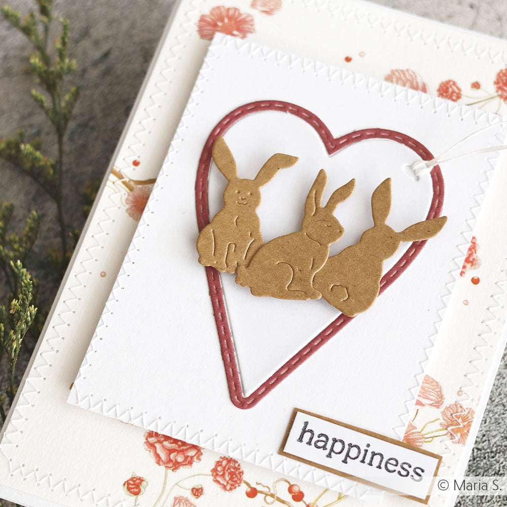 Handgemachte Karte mit drei braunen Häschen in einem gestickten roten Herz mit Blumen und "Glück", hergestellt mit der Hoppel Trio Motivstanze von Alexandra Renke. Ideal für Fans von PAPPcut®ies und Deep Edge Motivstanzen.