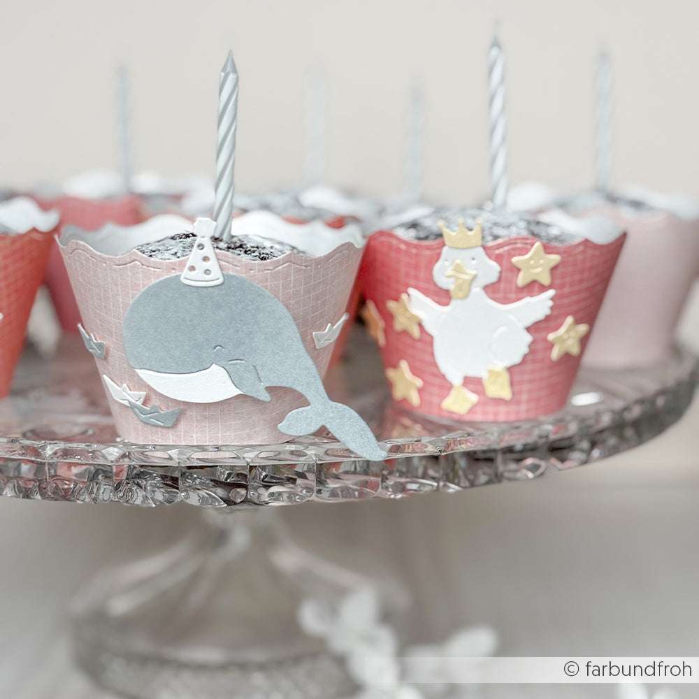 Cupcakes mit Tier- und Sternmotiven, jeweils mit einer Kerze gekrönt, arrangiert auf einem gläsernen Tortenständer - wunderschön gestaltet mit Alexandra Renke PAPPcut®ies und Deep Edge Motivstanzen für zusätzlichen Charme.