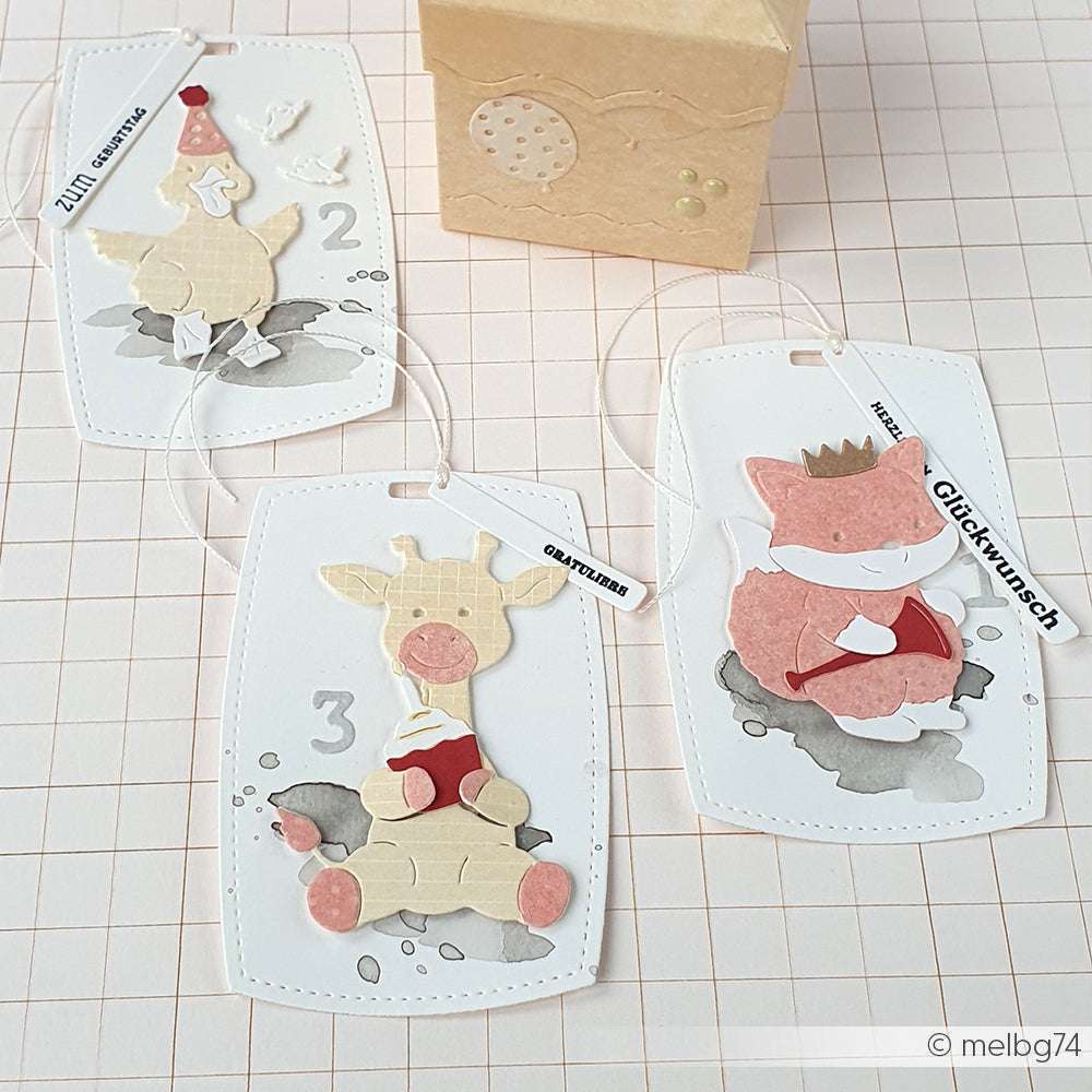 Drei handgefertigte Tiergeschenkanhänger, die mit Alexandra Renke Deep Edge Stanzen erstellt wurden, werden in einer kleinen braunen Schachtel auf einem rosa Gitterhintergrund präsentiert - perfekt für PAPPcuties-Fans.