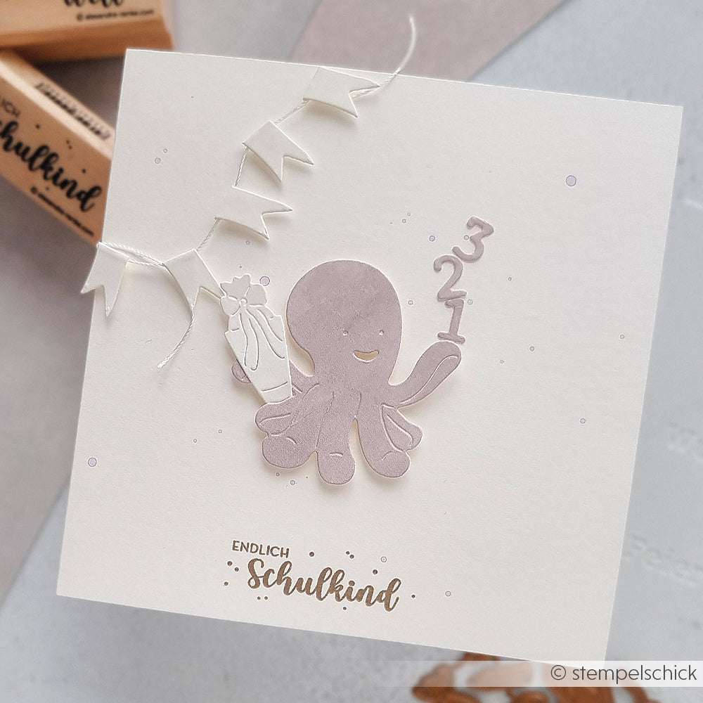 Quadratische Karte von Alexandra Renke mit der Motivtanze Glücklicher Oktopus in Lila, die die Zahlen 3, 2 und 1 hält, mit einem Banner und dem Text "Endlich Schulkind" am unteren Rand.