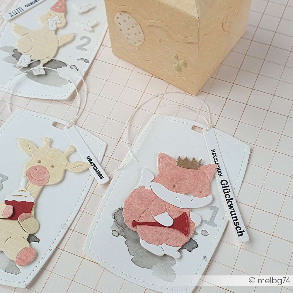 Handgefertigte tierische Geschenkanhänger mit deutschem Text, die einen Fuchs und eine Giraffe zeigen, hergestellt mit Alexandra Renke Motivstanze Fuchs und PAPPcut®ies auf einer gitterartigen Oberfläche.