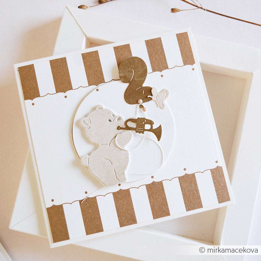 Ein niedlicher Bär spielt Trompete mit einem fliegenden Schmetterling auf einer braun-weiß gestreiften, handgefertigten Karte, die mit Alexandra Renke Deep Edge Stanzen für scharfe, detaillierte Kanten hergestellt wurde.