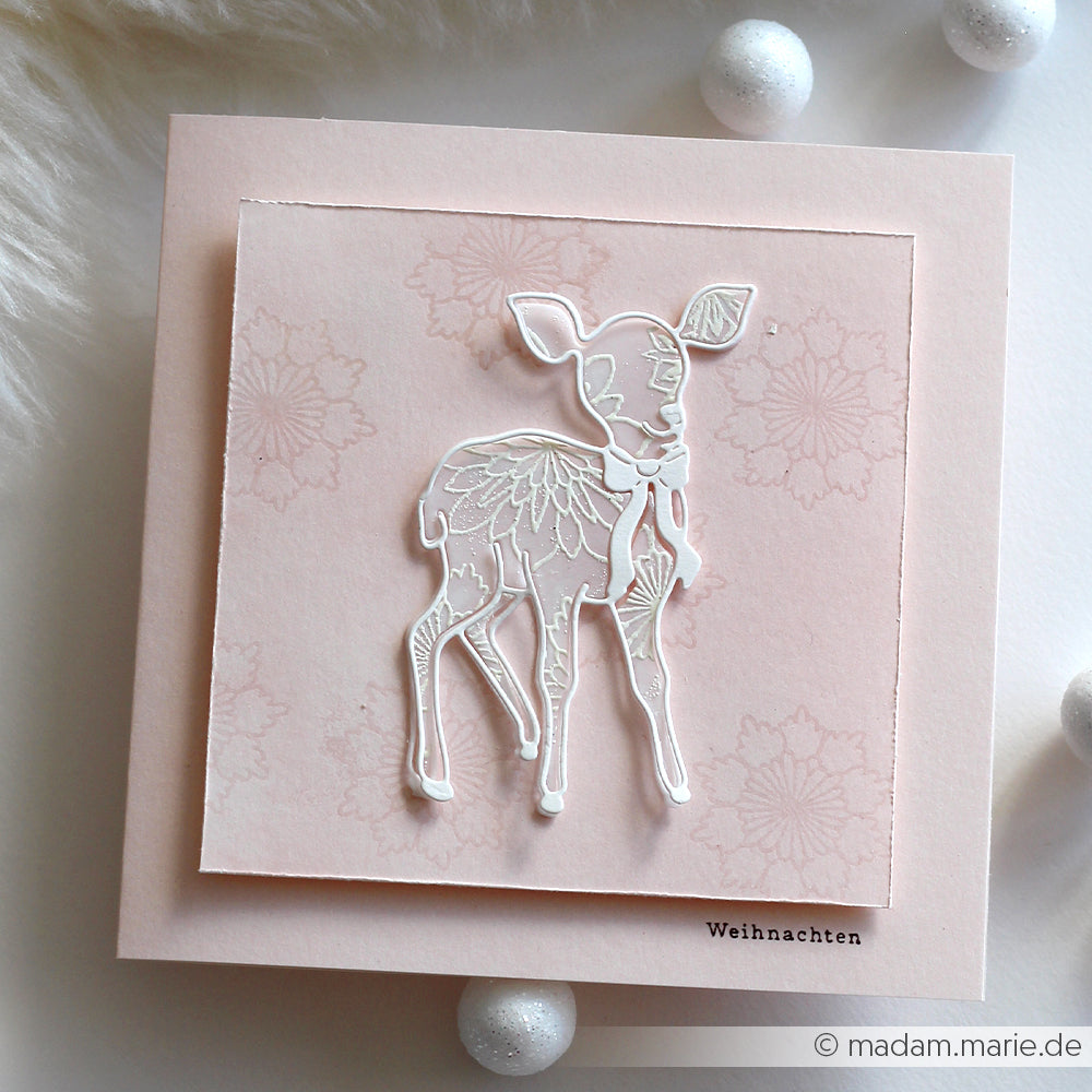 Handgefertigte rosa Weihnachtskarte von Alexandra Renke mit einem weiß umrandeten Rehkitz (Motivstanze Reh die), zarten Blumenmustern und der Aufschrift "Weihnachten".