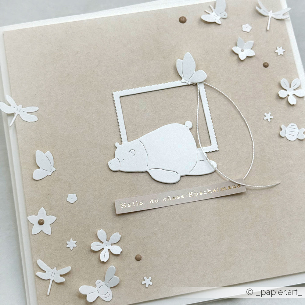Handgefertigte Karte von Alexandra Renke mit weißem Bären, Schmetterlingen, Blumen und deutschem Text auf beige, hergestellt mit Motivstanze Wiesenzauber und Designpapieren für ein charmantes Finish.