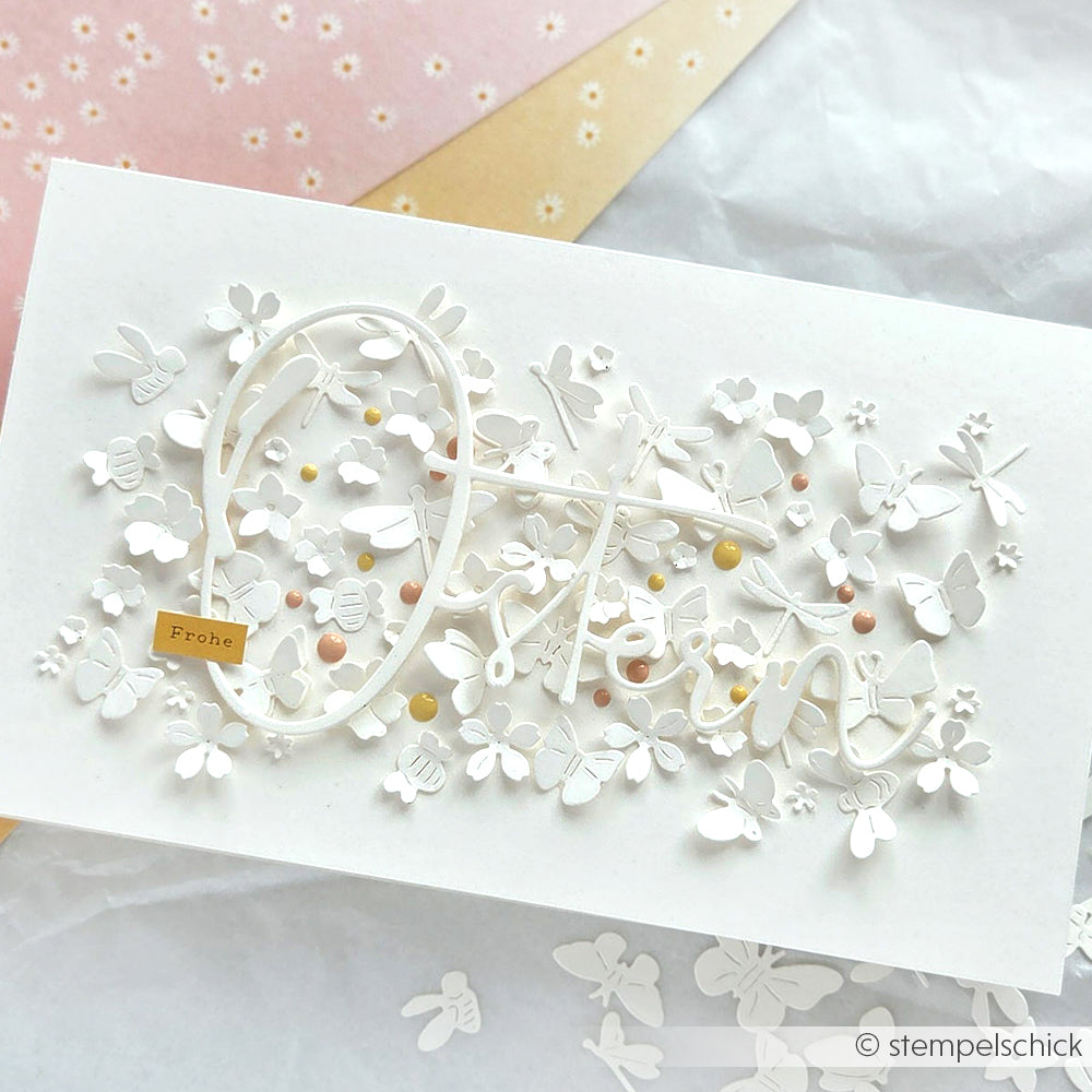 Handgefertigte weiße Karte von Alexandra Renke mit zarten 3D-Schmetterlingen, Blumen, Ostern in Schreibschrift und "Frohe Tag", gestaltet mit Designpapieren und der Motivstanze Wiesenzauber für zusätzlichen Charme.