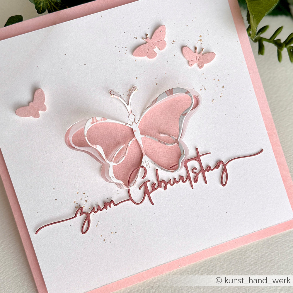 Handgefertigte rosa-weiße Geburtstagskarte mit Schmetterlingen, hergestellt mit Alexandra Renke Produkten, mit dekorativem Papier und elegantem kursivem Text "zum Geburtstag".