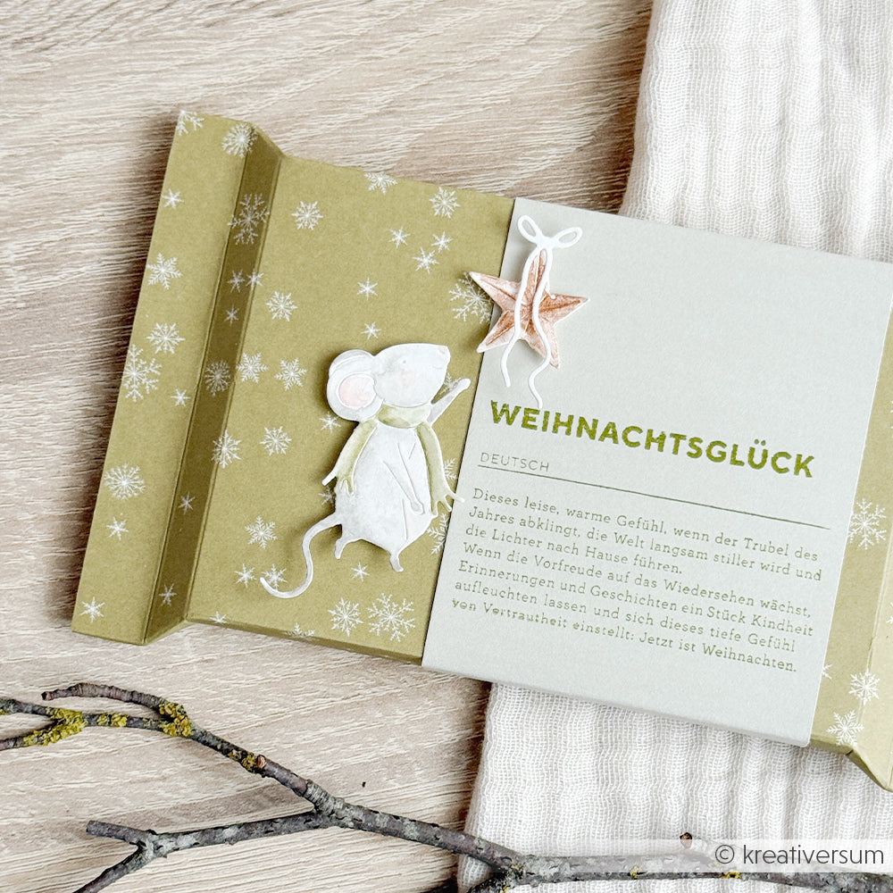 Olivgrüne Weihnachtskarte mit einer Illustration der Zauberhaften Maus, einem Papierstern und deutschem Text.