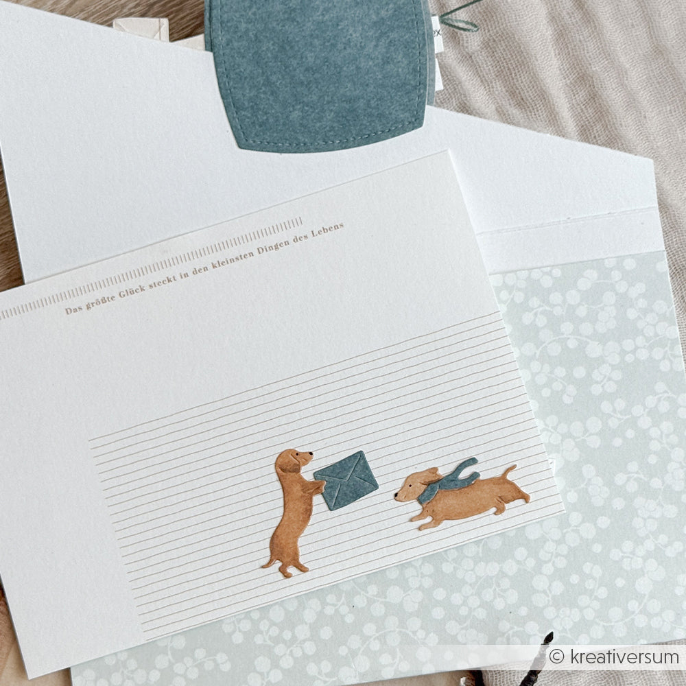 Liniertes Briefpapier mit Illustrationen von zwei Dackeln, deutschem Text und der Motivstanze Dackelspaß.
