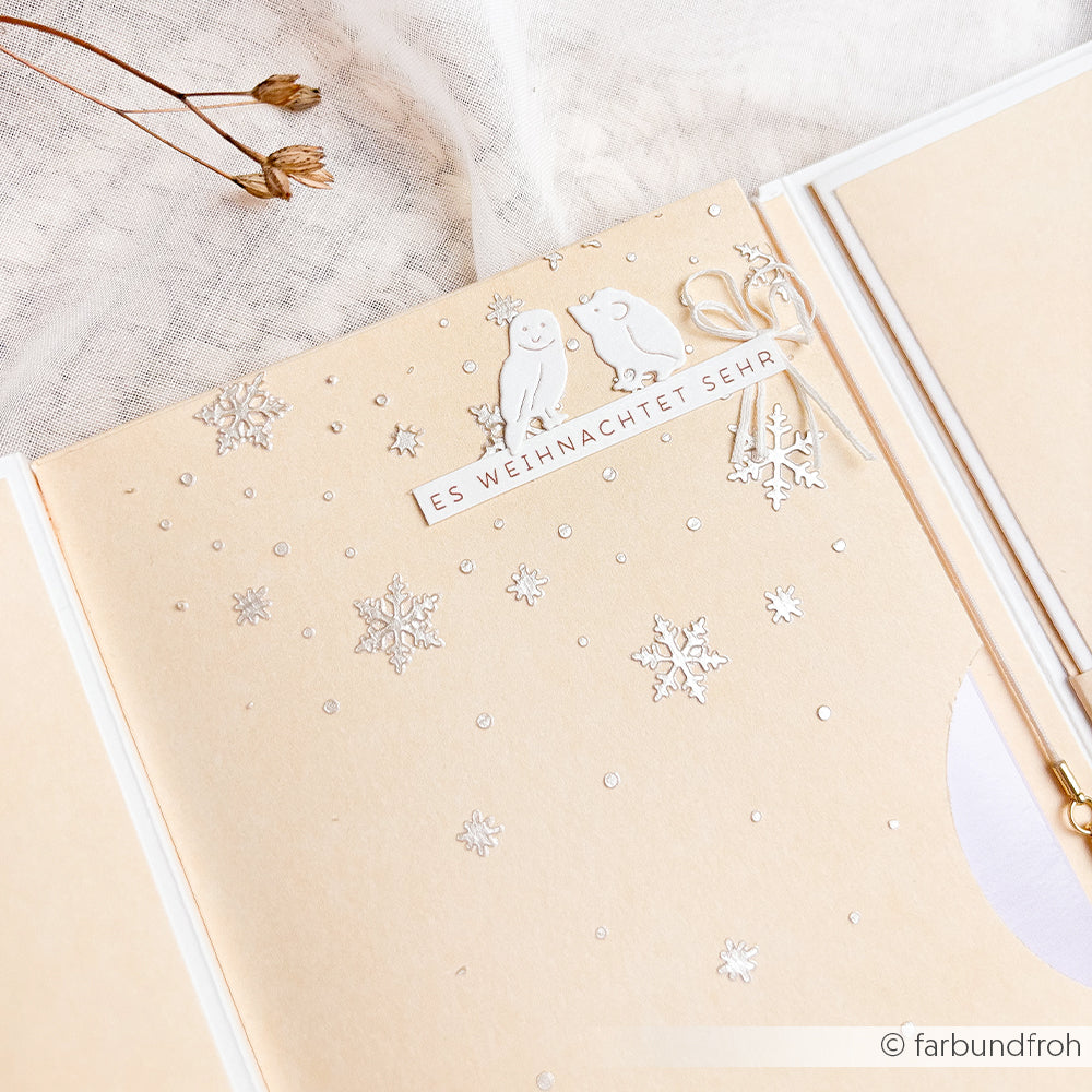 Handgefertigte Karte mit einer Eule, einem Igel und dem Schriftzug ES WEIHNACHTET SEHR inmitten von ausgestanzten Winterschneeflocken.