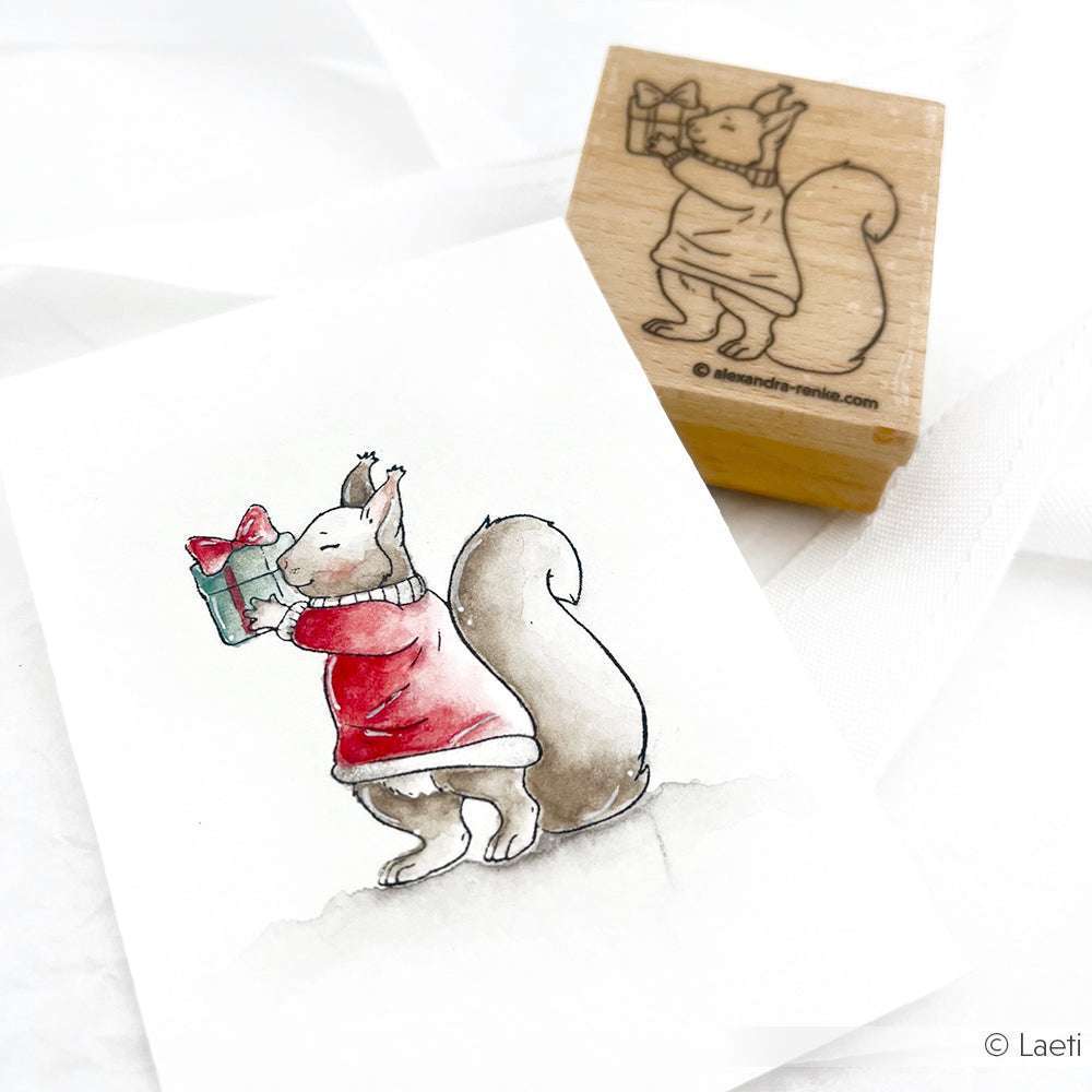 Illustration und Stempel eines Eichhörnchens mit Geschenk in einem roten Pullover, das ein eingepacktes Geschenk hält. Von Alexandra Renke-ideal für charmante Karten mit Stempelgummi oder Holzstempel.