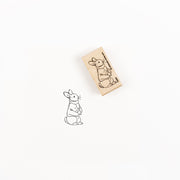 Ein Holzstempel von Hase Hoppel, unten mit seinem Stempelmotiv abgebildet.