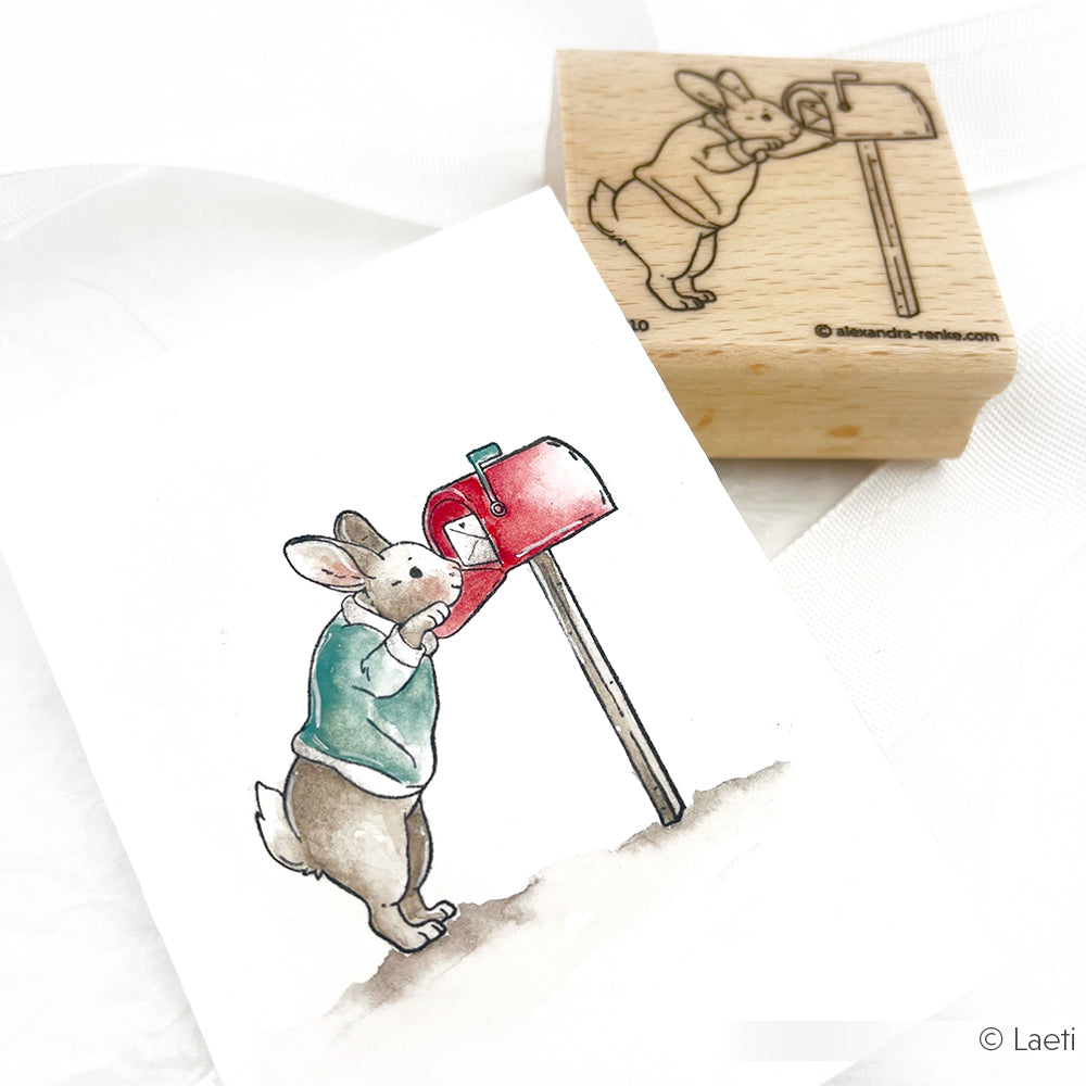 Ein Aquarell und ein Hopsi-Kaninchen-Stempel, auf dem ein Kaninchen zu sehen ist, das Post aufgibt.
