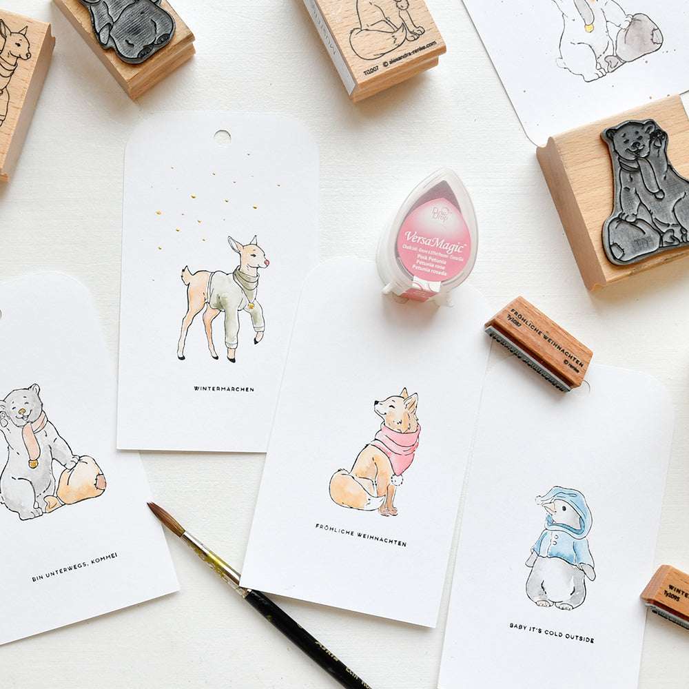 Die von Alexandra Renke illustrierten Tierkarten, Stempel, ein Stempelkissen und ein Pinsel, die auf einer weißen Fläche angeordnet sind, bringen kreatives Flair in Ihren Arbeitsbereich.