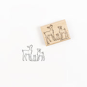 Ein Holzstempel und sein Abdruck, der zwei Rehkälber und ein Kaninchen zeigt.