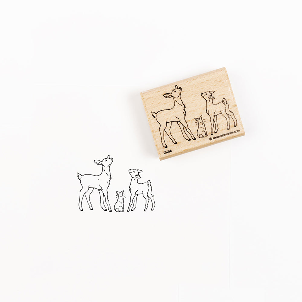 Ein Holzstempel und sein Abdruck, der zwei Rehkälber und ein Kaninchen zeigt.
