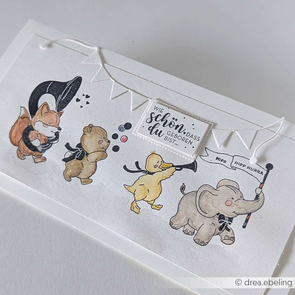Vier Tiere mit schwarzen Schleifen, darunter ein bannerschwingender Elefant, feiern mit Bannern und Instrumenten auf einer weißen Karte mit deutschem Text - perfekt für Papierprojekte oder zur Verwendung mit Ihrem Lieblingsholzstempel von Alexandra Renke.