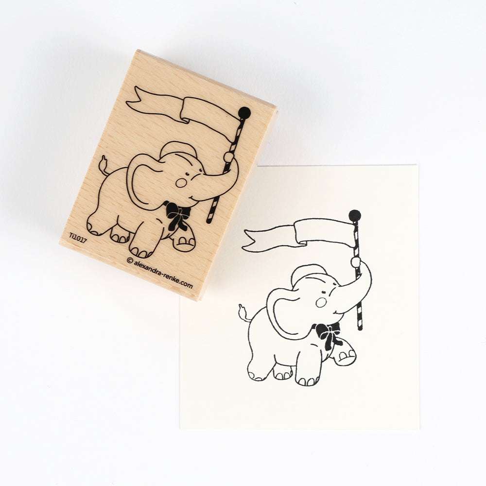 Ein entzückender Holzstempel von Alexandra Renke, der einen fahnenschwenkenden Elefanten zeigt, komplett mit seinem gestempelten Bild.