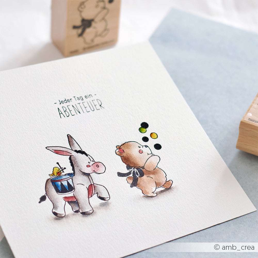 Eine Zeichnung von Alexandra Renke zeigt einen Esel und ein kleines Schwein mit Luftballons, mit detailreichen Motiven und dem deutschen Text "Jeder Tag ein Abenteuer".